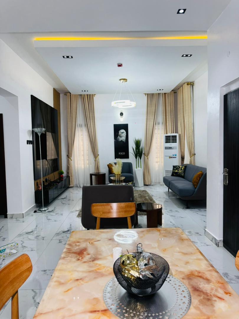 A living room with marble floors and tall curtains