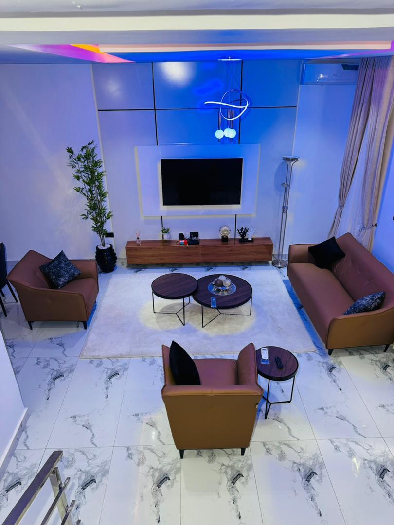 A double-height living room with leather armchairs