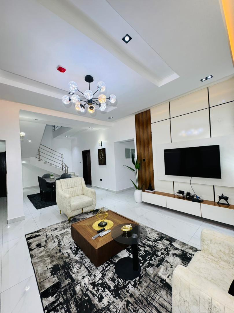 A living room beside the staircase, with a chandelier